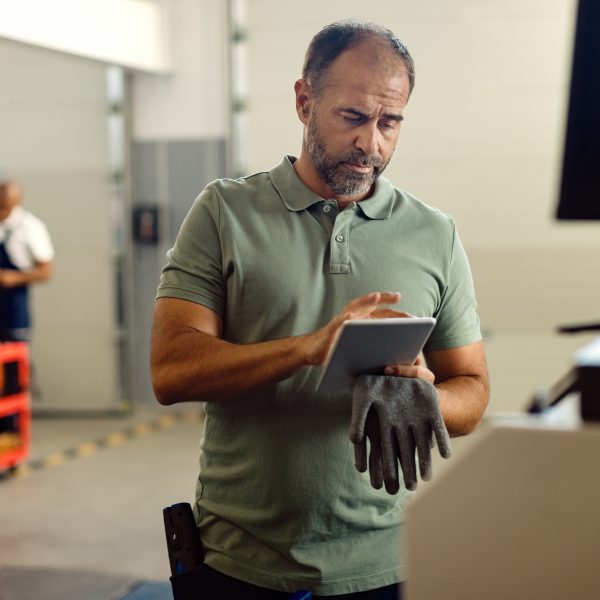 Meister in einer Werkstatt in Oberbayern nutzt ein Tablet mit ERP-Software zur Prozessoptimierung direkt an der Maschine.
